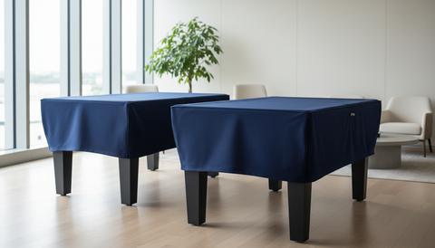 Housse sur-mesure en tissu bleu marine recouvrant un baby-foot et un billard dans un espace de réception élégant